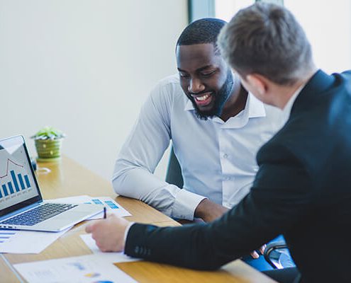 Two men discussing SEO services in NYC. SEO optimization is important for businesses to rank higher on Google.