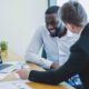 Two men discussing SEO services in NYC. SEO optimization is important for businesses to rank higher on Google.